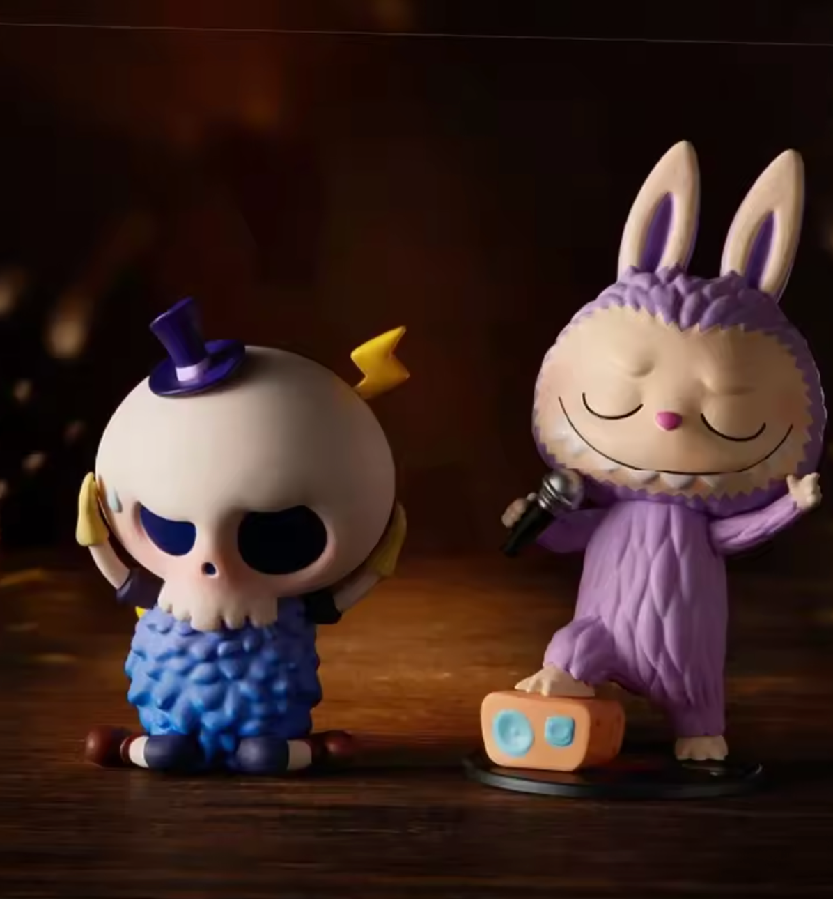Two figurines, one with a skull design and the other in a purple outfit, on a wooden surface.